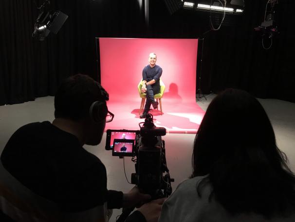 Shirish Kulkarni filming in University of South Wales studio in front of pink backdrop