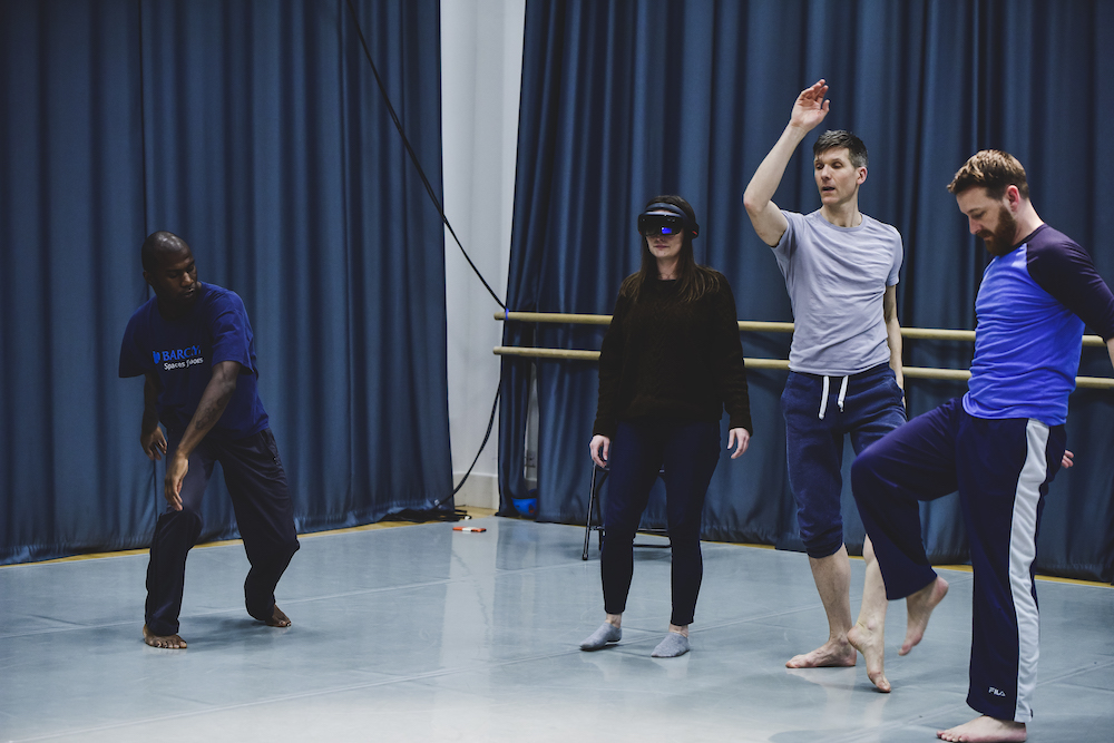 Trio of male dancers dancing with audience member wearing AR technology