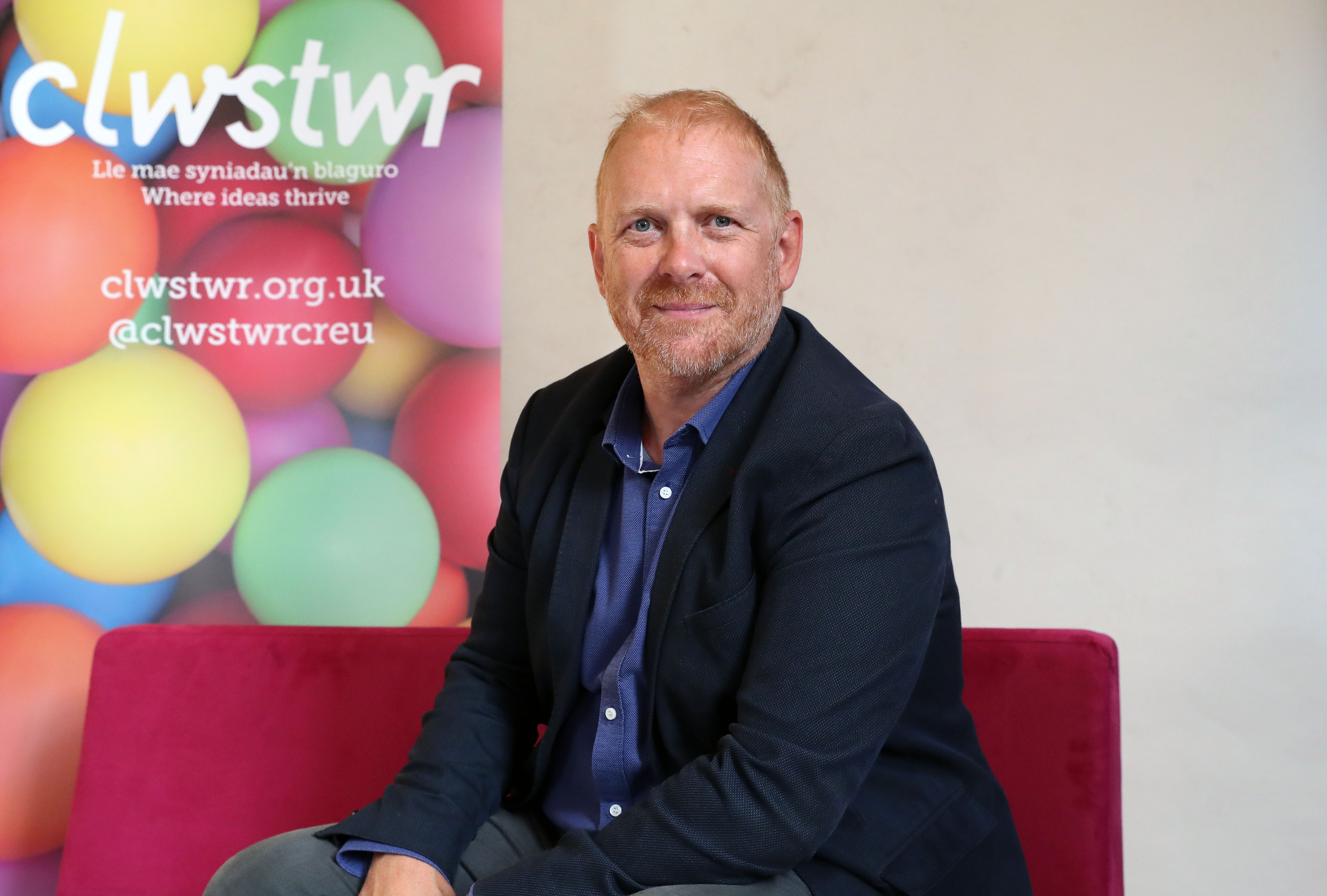 Rich Moss, MD of Gorilla infront of Clwstwr banner